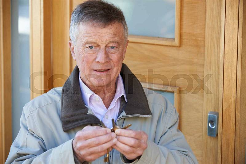 Confused Senior Man Trying To Find Door Key, stock photo