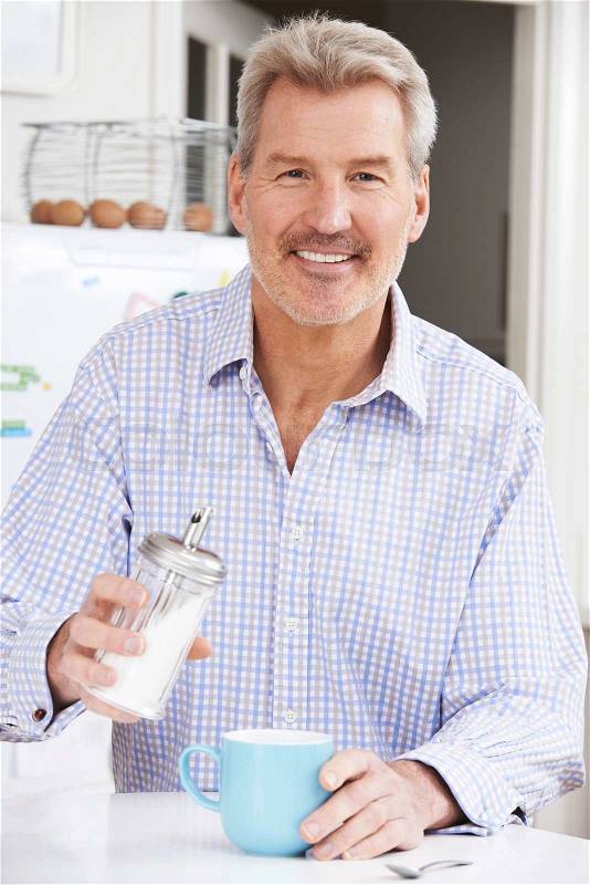 Mature Man Adding Sugar to Cup Of Coffee, stock photo