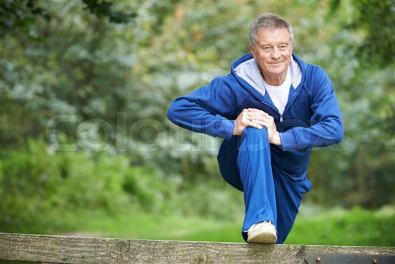 Senior Man Stretching On Countryside Run, stock photo