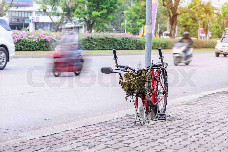 Broken bicycle locked with pillar in city, stock photo