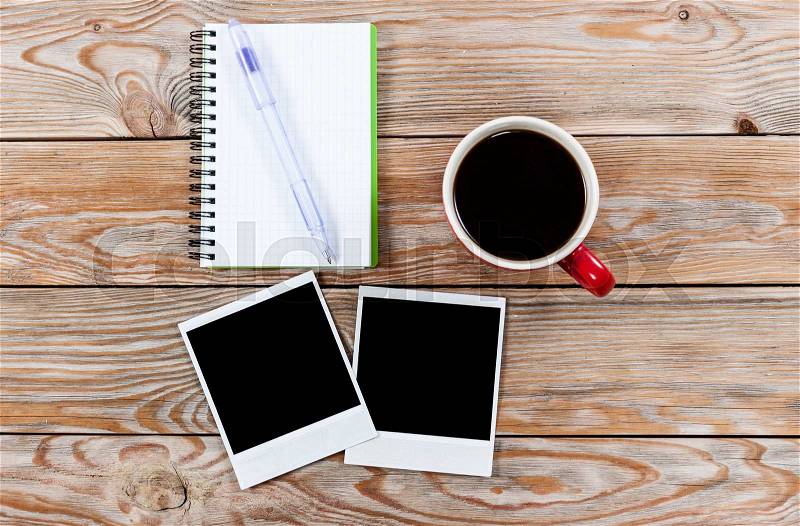 Workspace with coffee cup, instant photos, note paper and notebook on old wooden table. Business concept, stock photo