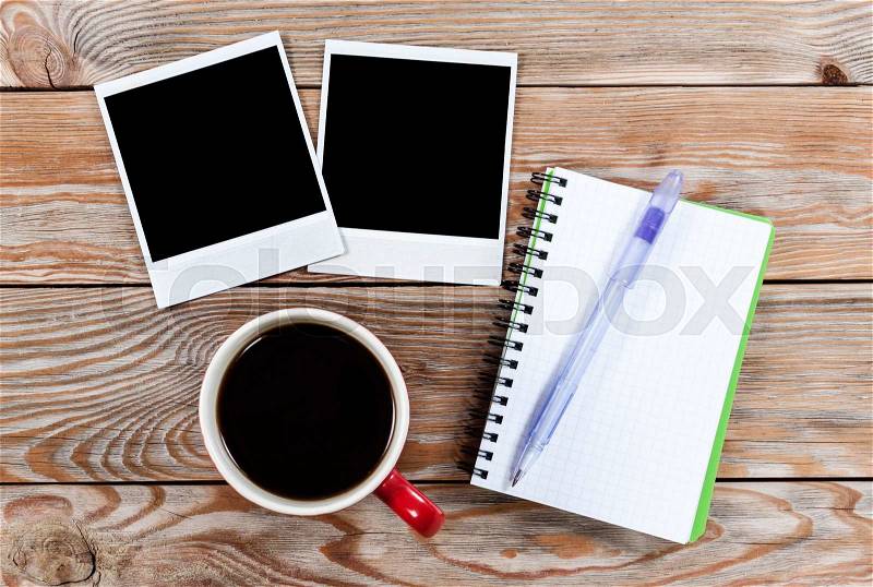 Workspace with coffee cup, instant photos, note paper and notebook on old wooden table. Business concept, stock photo