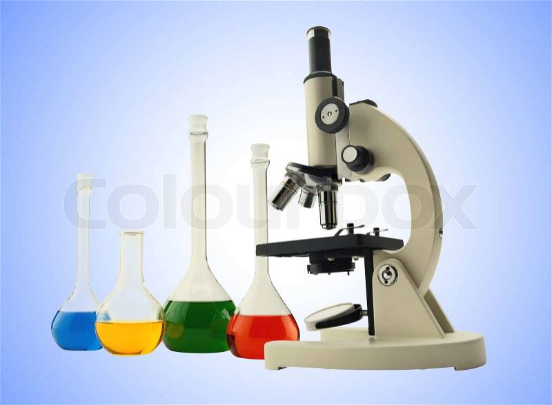Laboratory metal microscope and test tubes with liquid over blue, stock photo
