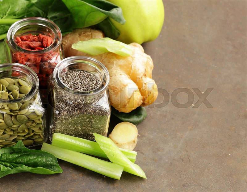 Super food - goji berries, chia seeds and pumpkin seeds with vegetables, fruits and herbs, stock photo