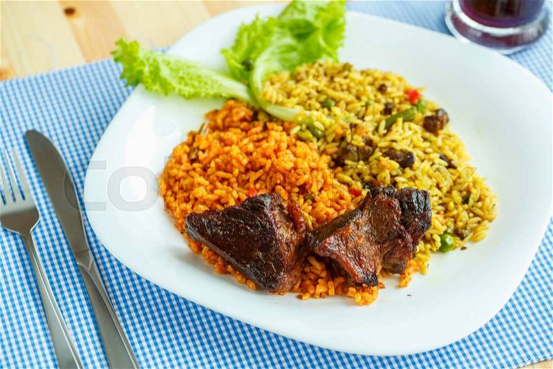 Delicious dish of roast beef with rice and salad leaves, stock photo