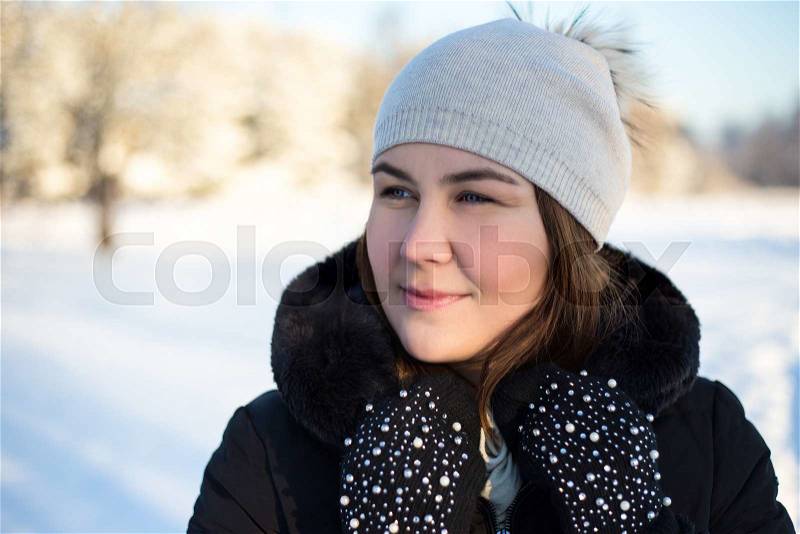 Close up portrait of young beautiful woman walking in winter forest, stock photo