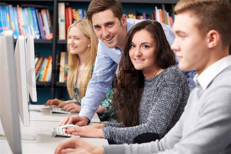 Tutor Helping Students Working At Computer, stock photo