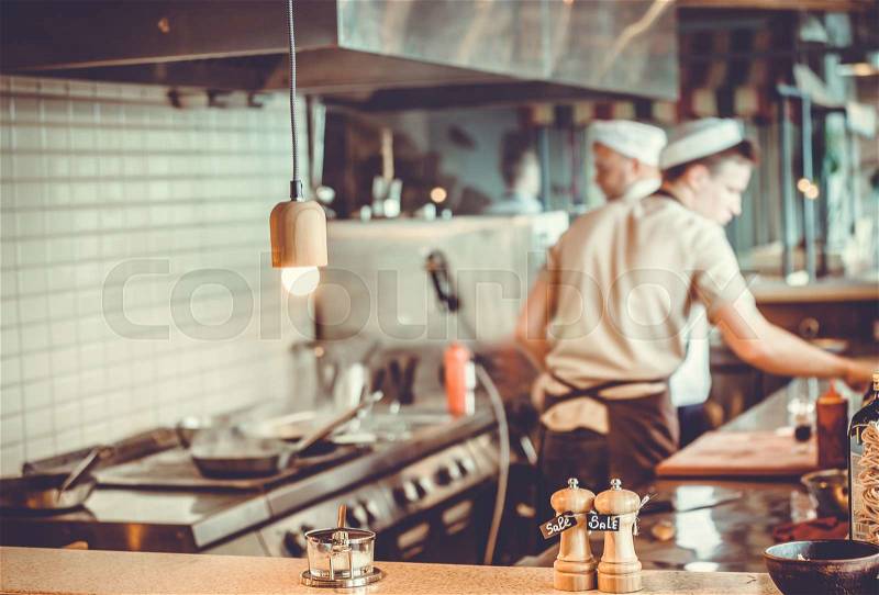 Blurred restaurant interior with salt and pepper on table, stock photo