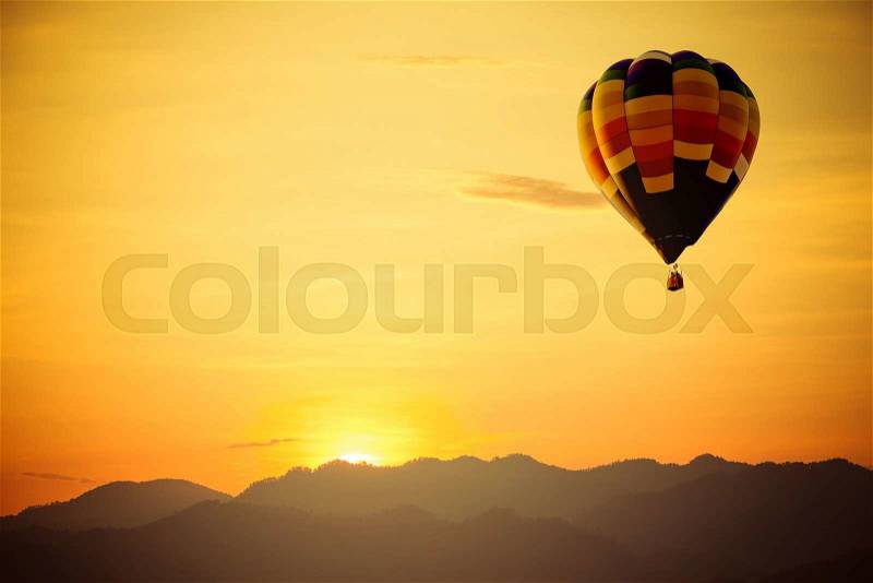 Hot air balloon flight over mountain with sunset, stock photo
