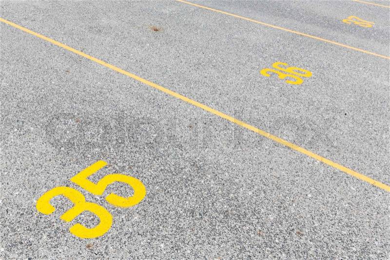 Concrete road texture with yellow color lines and numeric, outdoor parking lot, empty street, stock photo