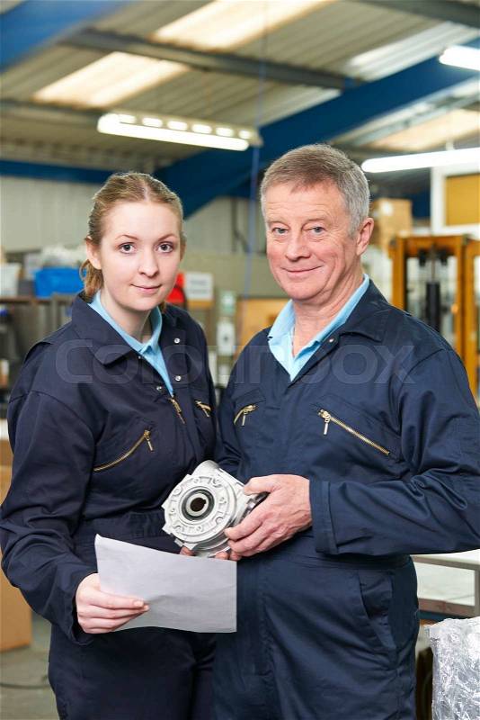 Engineer And Apprentice With Component In Factory, stock photo