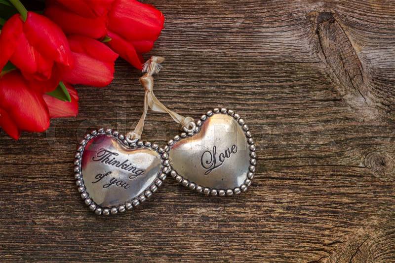 Pair of Lover hearts with red tulip flowers on wood, stock photo