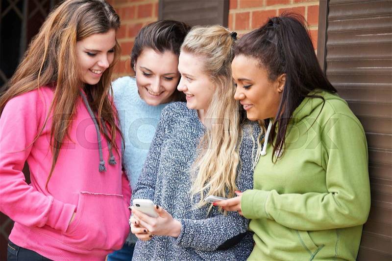 Group Of Teenage Female Friends Reading Text Message, stock photo