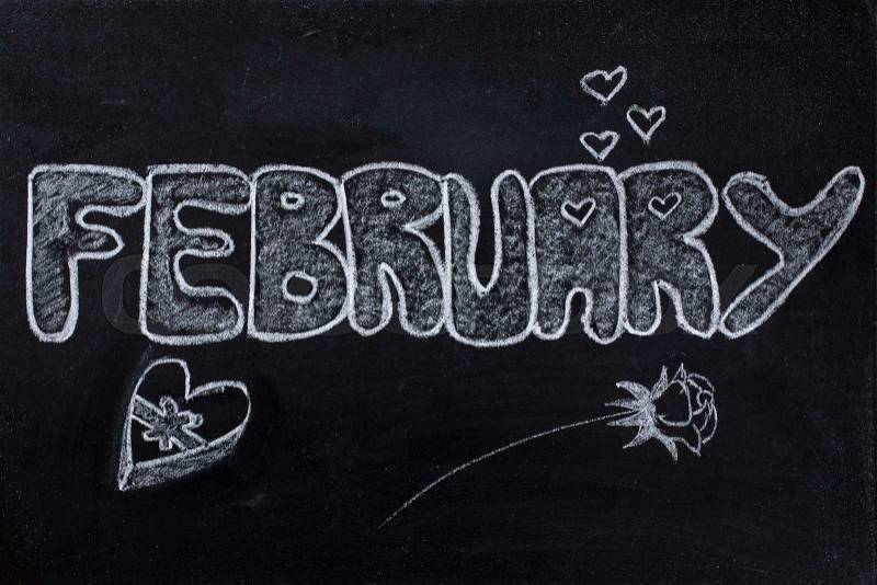 Handwritten February with Valentine days symbols, rose, hearts and chocolate box on black chalkboard, stock photo