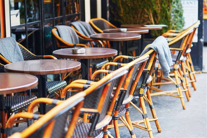 Warm plaid on the chair of cozy outdoor Parisian cafe on a winter day, stock photo