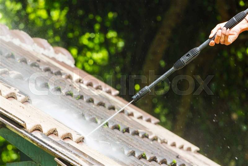 Roof cleaning with high pressure water cleaner, stock photo