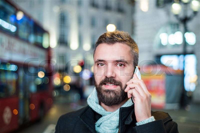 Young handsome man with smart phone in London city, stock photo