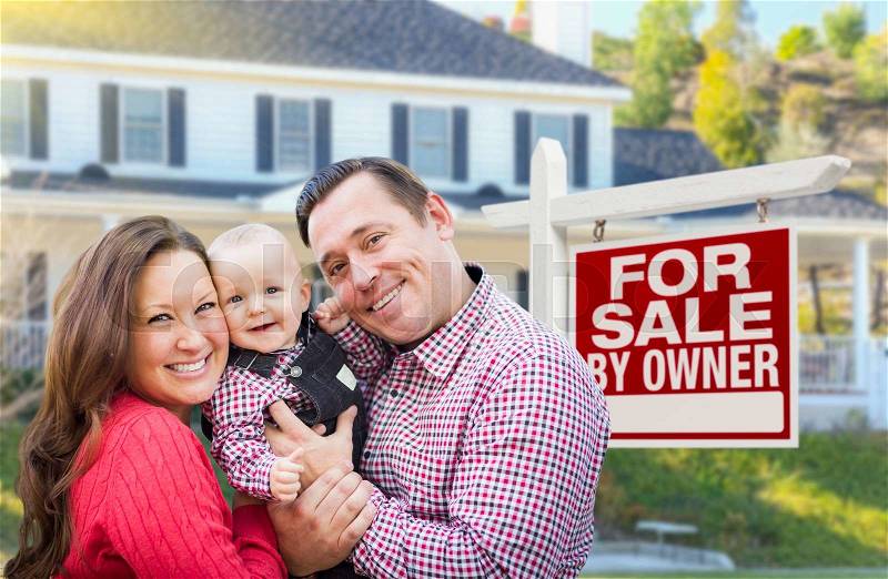 Happy Young Family In Front of For Sale By Owner Real Estate Sign and House, stock photo