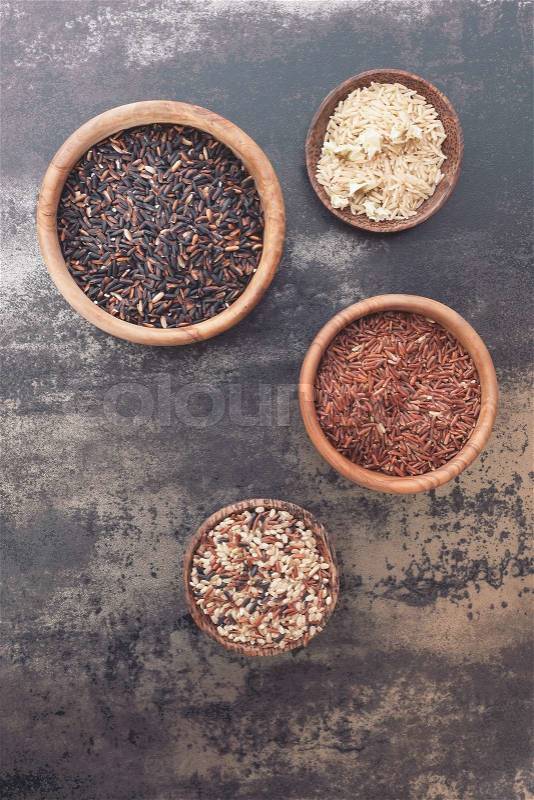 Different types of rice in small bowls Still life with four different types of rice. Top view, vintage toned image, blank space, stock photo