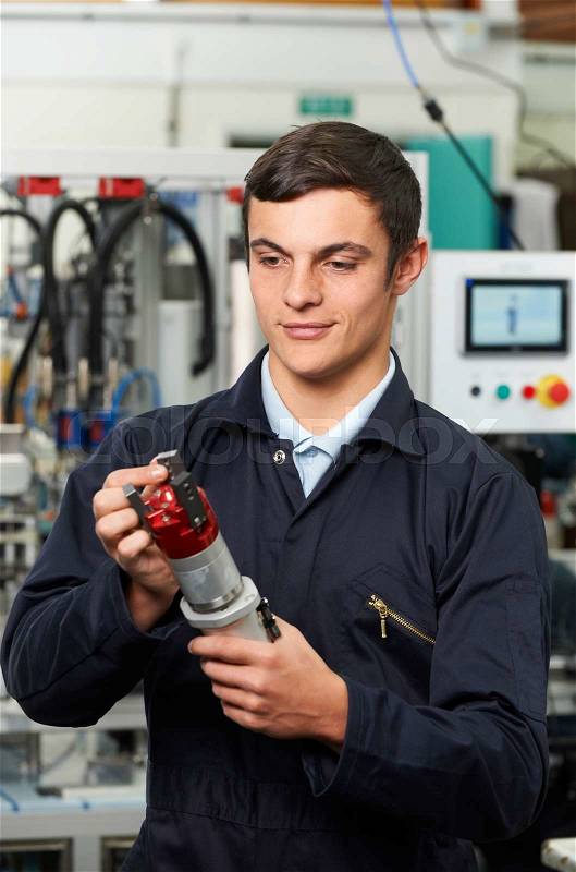 Apprentice Engineer Checking Component In Factory, stock photo