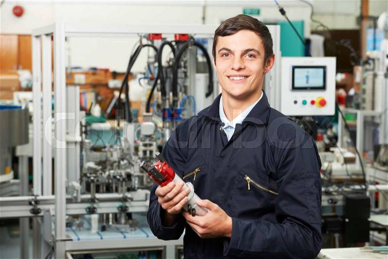 Apprentice Engineer Checking Component In Factory, stock photo