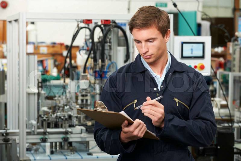 Engineer Writing On Clipboard In Factory, stock photo