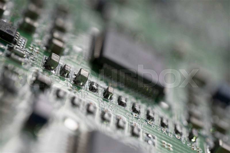 Detail of an electronic printed circuit board with many electrical components with swallow depth of field, stock photo