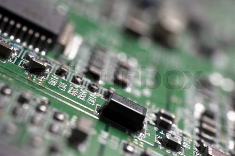 Detail of an electronic printed circuit board with many electrical components, stock photo
