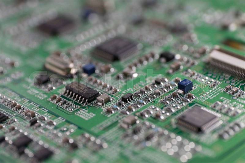 Detail of an electronic printed circuit board with many electrical components with swallow depth of field, stock photo