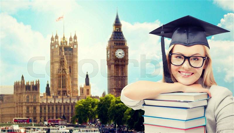 Education, school, knowledge and people concept - picture of happy student girl or woman in trencher cap with stack of books over houses of parliament in london city background, stock photo