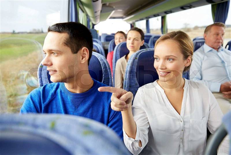 Transport, tourism, road trip and people concept - happy couple with group of happy passengers or tourists in travel bus, stock photo