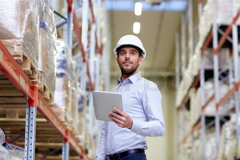 Wholesale, logistic, business, export and people concept - happy man or manager with tablet pc computer checking goods at warehouse, stock photo