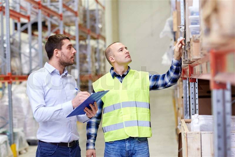 Wholesale, logistic, people and export concept - manual worker and businessmen with clipboards at warehouse, stock photo