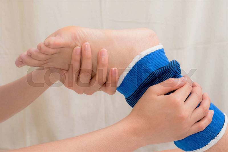 Patient with ankle sprain using ankle support stabilizer after rehabilitation, stock photo