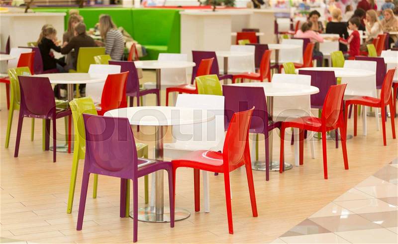 Interior of public dining area with colourul plastic chairs and tables, stock photo