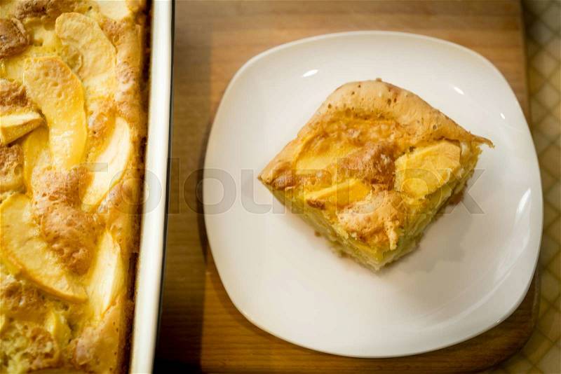 Freshly baked piece of homemade apple pie on white dish, stock photo