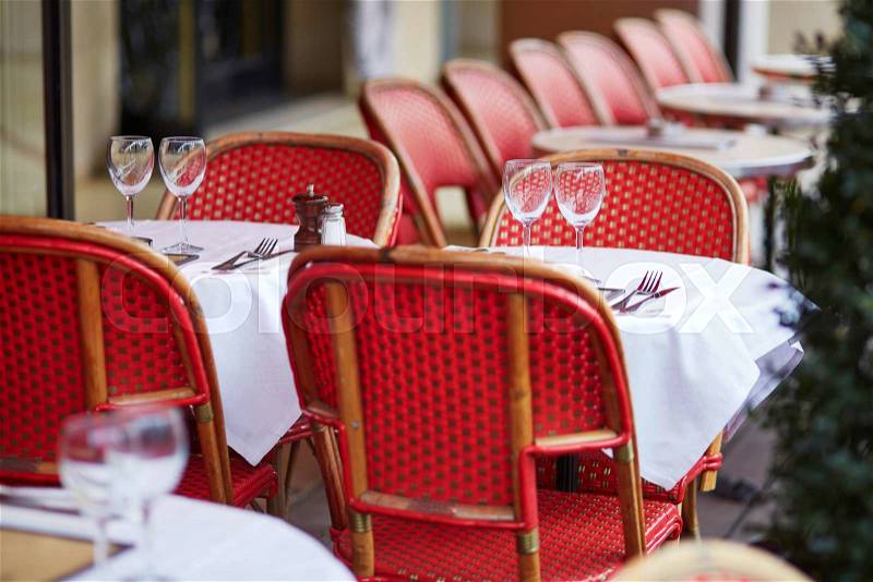 Tables of cozy outdoor cafe in Paris, France, stock photo