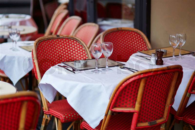Tables of cozy outdoor cafe in Paris, France, stock photo