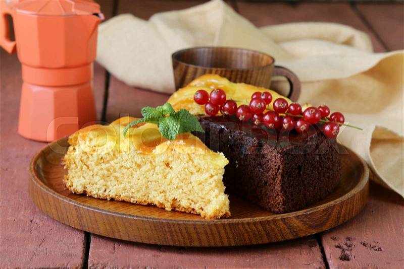 Assorted cake - chocolate and fruit on wooden plate, stock photo