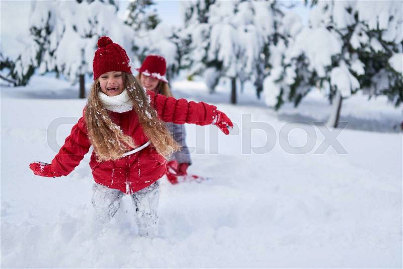 Daughter with mother play in snow-covered park in winter, stock photo