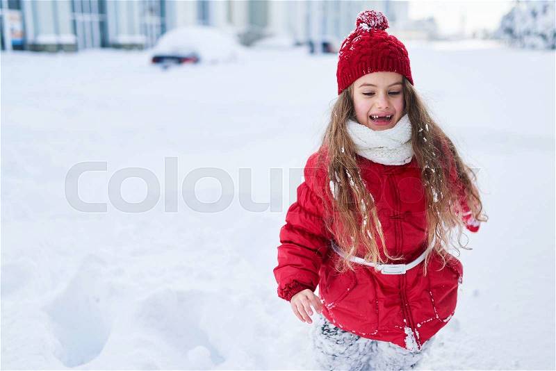 Child walks in a snowy winter park, stock photo