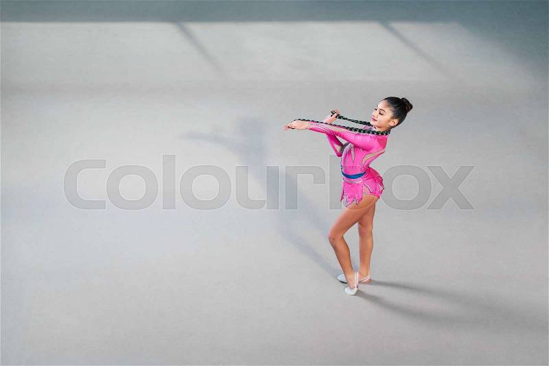 Gymnast in a beautiful dress dancing with a rope, stock photo