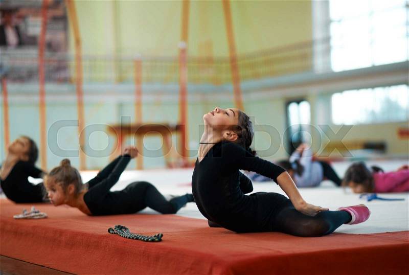 She kneads his back in training rhythmic gymnastics, stock photo