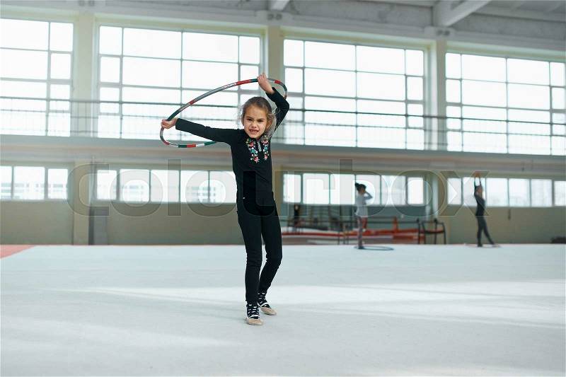 Beautiful girl gets angry with a hoop of rhythmic gymnastics, stock photo