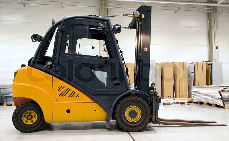 Yellow forklift loader in the large modern warehouse, stock photo