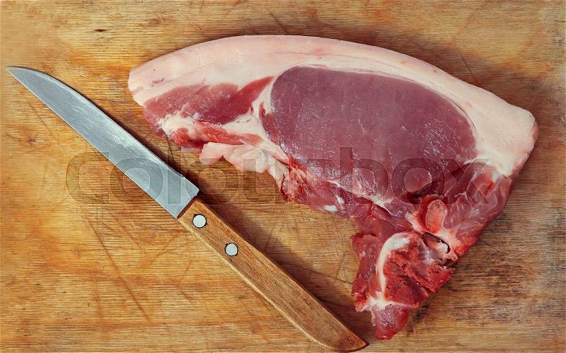 Raw pork meat and knife on wooden cutting board.Top view, stock photo