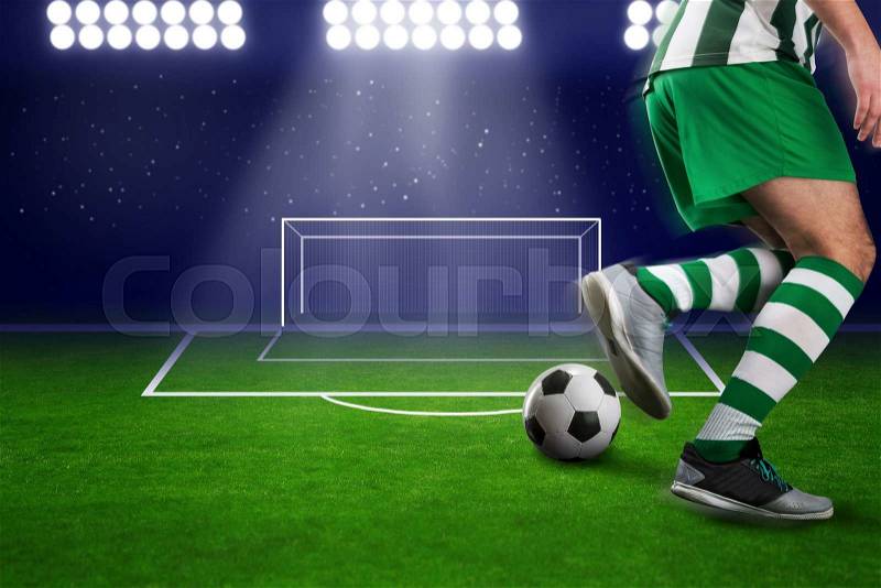 Football-player kicking the ball on the football ground, stock photo