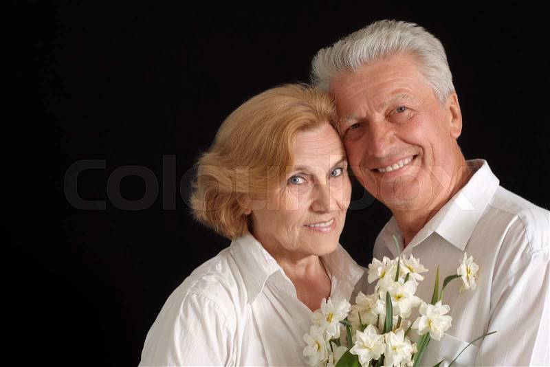 Nice old people with flowers on the black background, stock photo