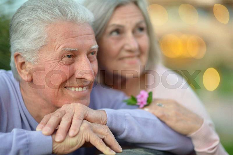 Amusing happy smiling old couple with flower, stock photo
