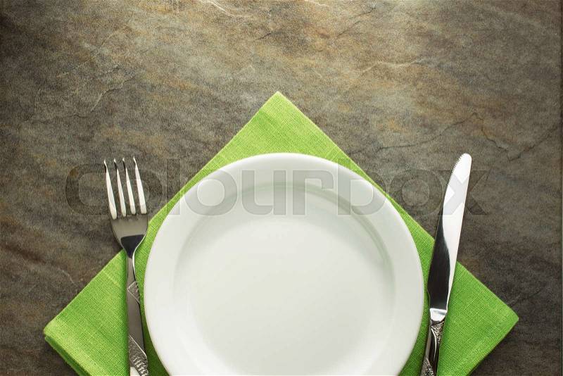 Plate, knife and fork on napkin cloth, stock photo